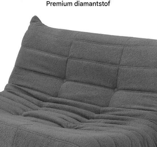 Dichtbij van de zachte, gewatteerde stof van een grijze vloersofa.