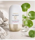 Lancaster Sun Perfect AIR SPF 50 Mineral sensitive, in verpakking met witte dop en gouden basis, omringd door witte stenen en groene blaadjes.
