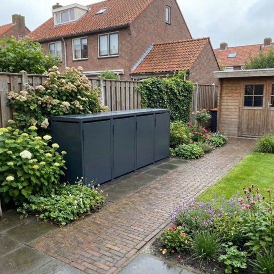 Donkergrijze kliko ombouw van drie vakken in een tuin met een pad van bakstenen en houten schutting.