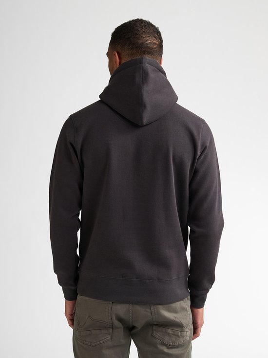 Achterkant donkere hoodie met oranje opdruk 'Petrol Industries & Co.', op een man.