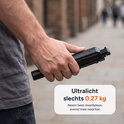 Hand die een opgevouwen, zwarte selfiestick vasthoudt. 'Ultralicht slechts 0.27 kg'.