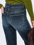Close-up van de achterkant van een spijkerbroek in donkerblauw denim met subtiele wassing. Twee zakken aan de achterkant.