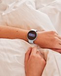 Damesarm met witte Samsung Galaxy Watch9 die een energiewaarde van 95 toont.