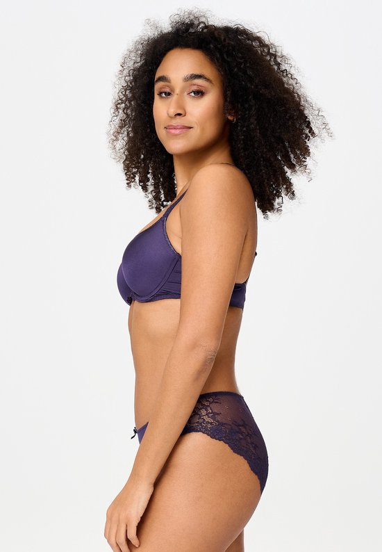 Zijaanzicht van model in een paarse T-shirt bh en slip met kanten zijpanelen.