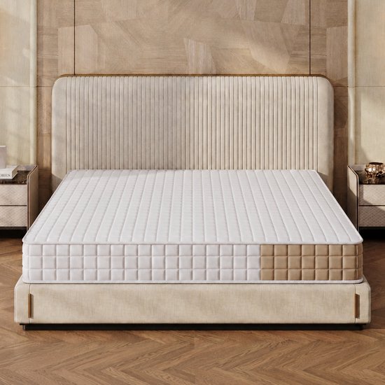 Matras in een moderne slaapkamer met een gestreept, beige hoofdbord en nachtkastjes. Matras is wit en geruit met een bruine accentstrook.