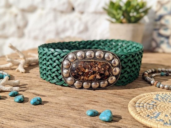 Groene gevlochten leren riem met ovale gesp ingelegd met steentjes en zilverkleurige bolletjes.
