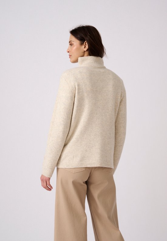 Vrouw met gebreide beige trui met col, van achteren gezien.