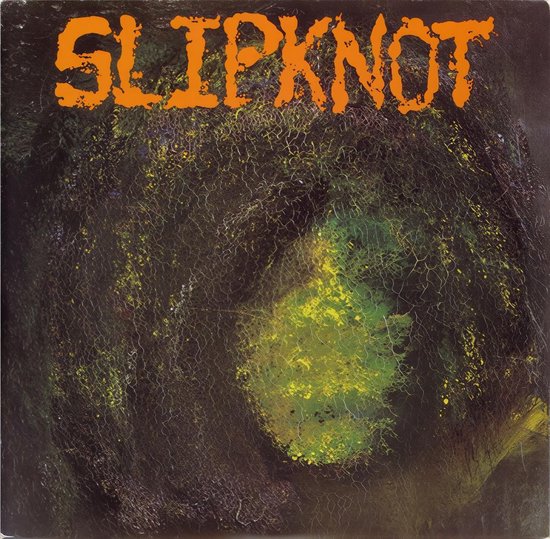 Albumhoes met de bandnaam SLIPKNOT in oranje letters. De achtergrond is donker en bemost met een gele gloed.