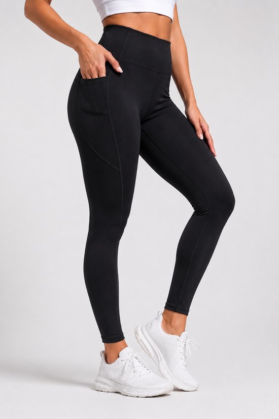 Zwarte sportlegging met hoge taille en steekzakken, getoond op model met witte sneakers.