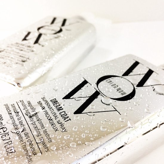 Twee zilverkleurige flessen met "WOW" logo en "DREAM COAT SUPERNATURAL SPRAY", bedekt met waterdruppels.