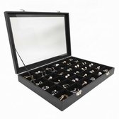 Zwarte juwelendoos, open met zicht op 36 vakjes gevuld met diverse ringen en kettingen.