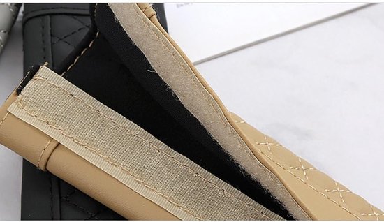 Close-up van de beige, doorgestikte gordelhoes met opengeklapte klittenbandsluiting.