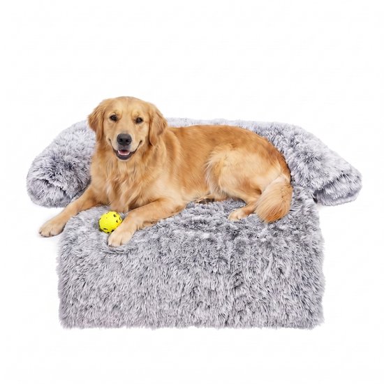 Gouden retriever met een gele bal op een fluffy grijs hondenbed.