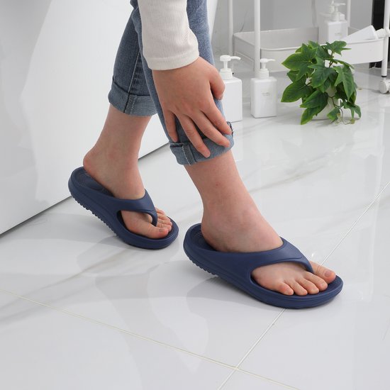 Blauwe OLANLY teenslippers met een ergonomisch ontwerp, gedragen door een persoon op een witte tegelvloer.