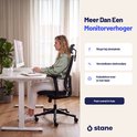 Vrouw aan een wit Stane bureau, met zwarte bureaustoel, bureau heeft kabeldoorvoer in het blad.
