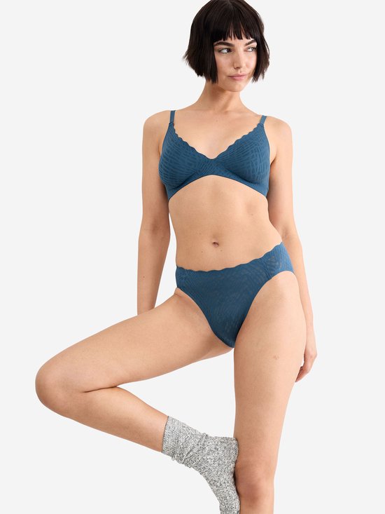 Model draagt donkerblauwe slip met golfvormige rand en visgraatpatroon, bijpassende bh.