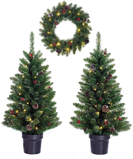 Een set van twee verlichte kunstkerstbomen met dennenappels en rode bessen, en een bijpassende kerstkrans, op een witte achtergrond.
