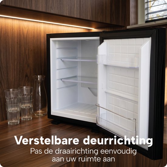 Open lege zwarte BREND koelkast met verstelbare deurrichting, in een keukenomgeving met glazen.