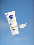 NIVEA Luminous 630 Anti-spot handcrème met SPF 15 en een druppel crème, zwevend in de lucht.