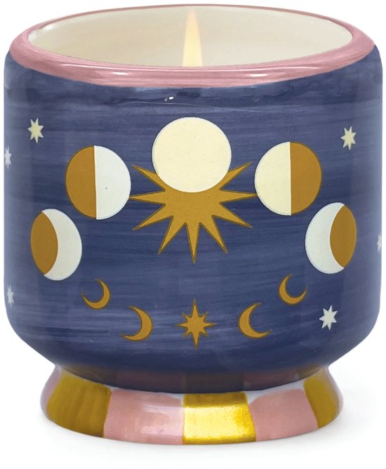 Een brandende blauwe kaars in een pot met gouden en witte maanfasen, sterren en een roze rand.