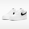 Paar witte sneakers van generfd leer met zwart Swoosh logo en zwarte hiel.