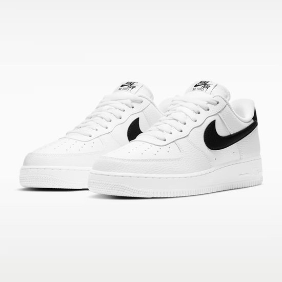 Paar witte sneakers van generfd leer met zwart Swoosh logo en zwarte hiel.