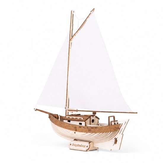 Houten modelbouwpakket zeilboot met witte zeilen, staand op een witte ondergrond.