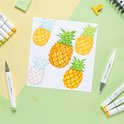 Vijf pinnenappels, waarvan drie gekleurd en twee in schetslijnen, op wit papier.