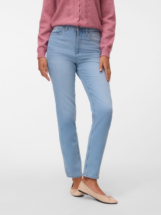 Model van voren in lichtblauwe mom fit jeans, gedragen met een roze vest en ballerina's.