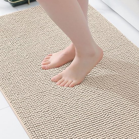 Voeten op een beige badmat met een zachte, bobbelige textuur.