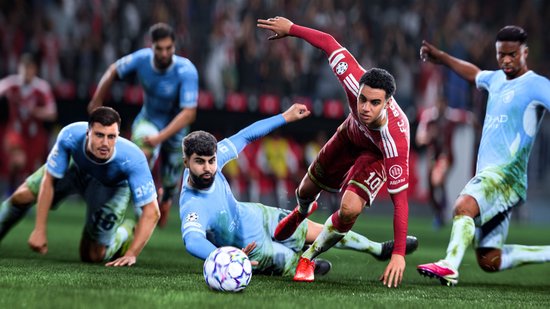 Voetballer in rood shirt met nummer 10 valt, terwijl spelers in lichtblauwe shirts hem proberen te tackelen.