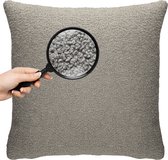 Grijze kussen met teddy textuur, vergrootglas toont de structuur.