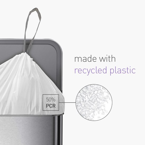Wit laken met trekband, 50% PCR, in een stalen prullenbak. Naast een cirkel met plastic korrels.