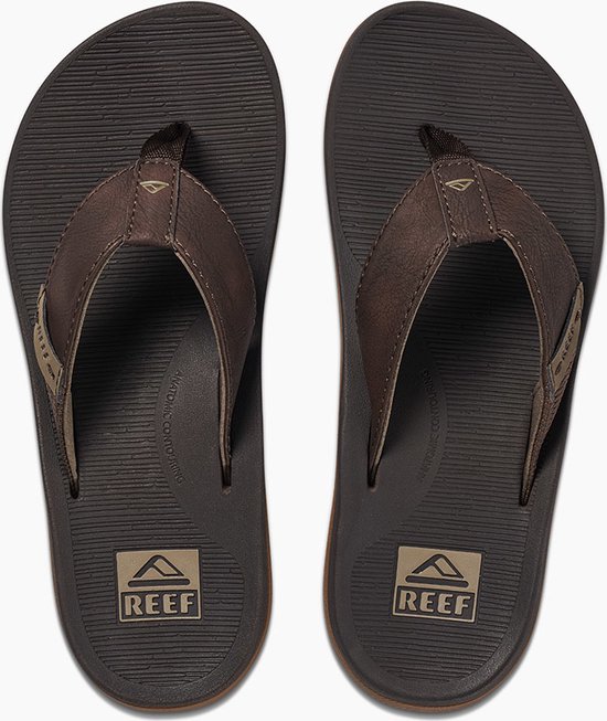 Paar bruine Reef teenslippers met Reef logo's op de binnenzool en gestructureerde bandjes.