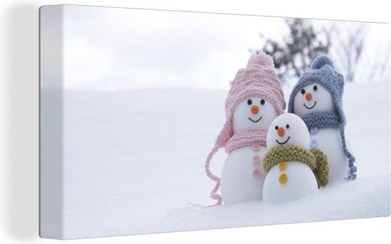 Canvas Schilderij Een familie van kerstpoppen op het besneeuwde landschap - 80x40 cm - Wanddecoratie