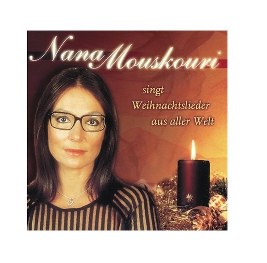 Nana Mouskouri zingt kerstliederen uit alle hoeken van de wereld. Ze draagt een bril en een ketting met een hartje. Een donkere kaars en kerstversiering op de achtergrond.