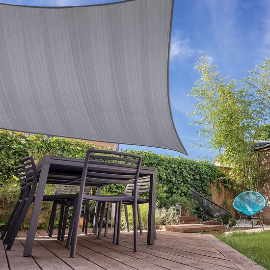 Grijze rechthoekige schaduwdoek boven een tuintafel met stoelen op een houten terras.