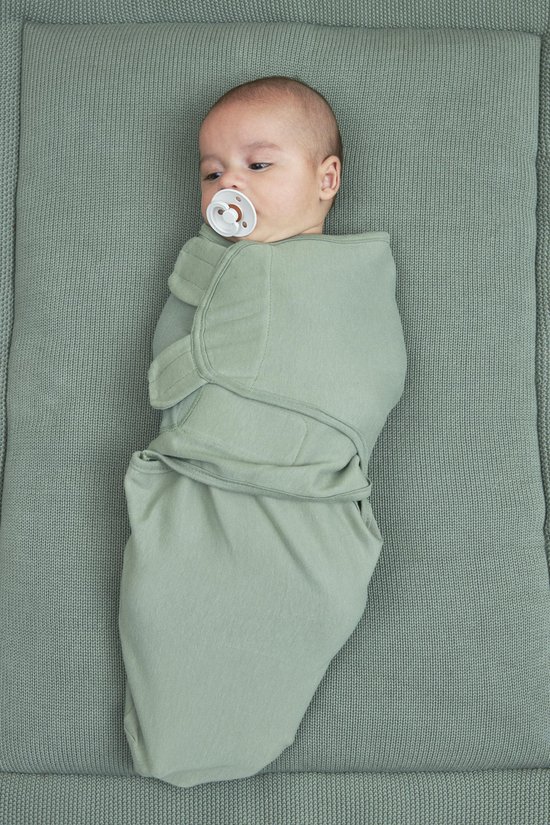Baby ingebakerd in een saliegroene Meyco inbakerdoek met speentje.