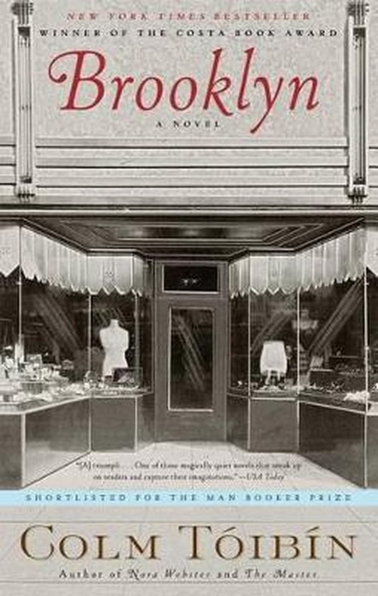 Boekomslag van "Brooklyn" door Colm Tóibín, met de titel in rode sierletters boven een afbeelding van een winkelpui.