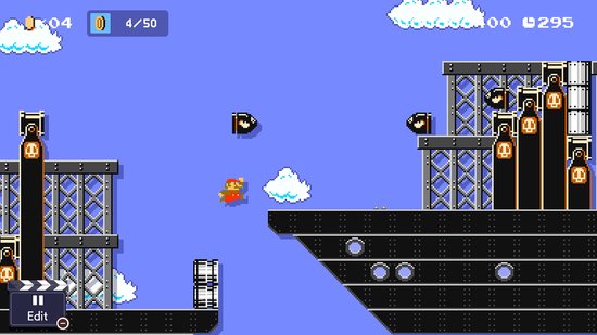 Een gele kat Mario loopt over een platform met grote mechanische bollen in de lucht.