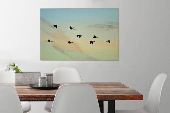 Tableau sur toile Un ciel bleu-jaune avec huit grues - 90x60 cm - Décoration murale