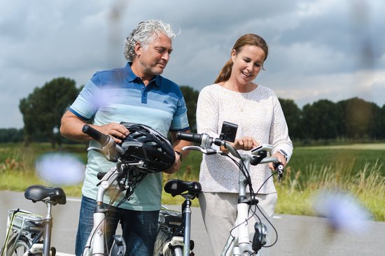 Man met helm en vrouw met fietsen kijken elkaar aan.