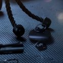 Zwarte draadloze sport oordopjes met oplaadcase op een fitnessmat, met touw.