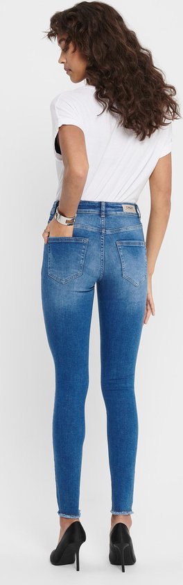 Achterkant van een model die een skinny jeans draagt, met lichtblauwe denim, vijf zakken en rafelige zoom.