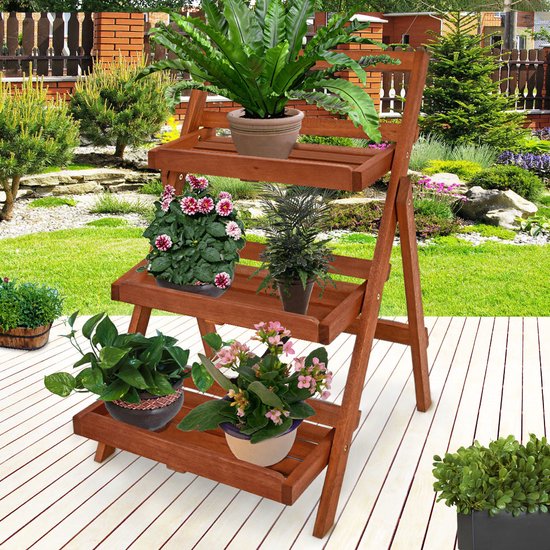 Bruin houten plantenrek met drie etages, met planten, in een tuin.