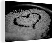 Canvas schilderij 150x100 cm - Wanddecoratie Hartvormpje in een hoop sesamzaad in een pan - zwart wit - Muurdecoratie woonkamer - Slaapkamer decoratie - Kamer accessoires - Schilderijen
