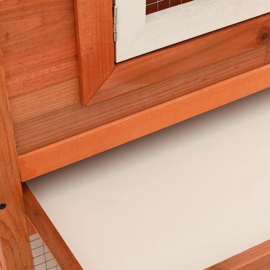 Detail van de witte lade en houten structuur van een konijnenhok.