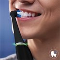 Close-up van een persoon die zijn tanden poetst met een zwarte Oral-B iO elektrische tandenborstel.