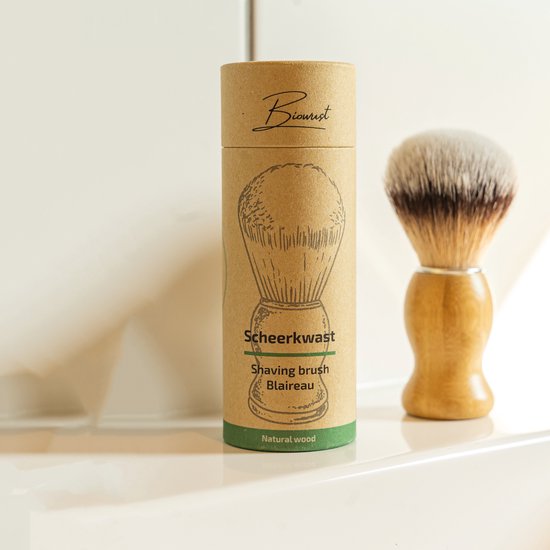 Beschrijving van de 'Scheerkwast Blaireau' met bamboe handvat en bruin-witte haren, in de verpakking. Titel: 'Scheerkwast', 'Shaving brush Blaireau', 'Natural wood'.