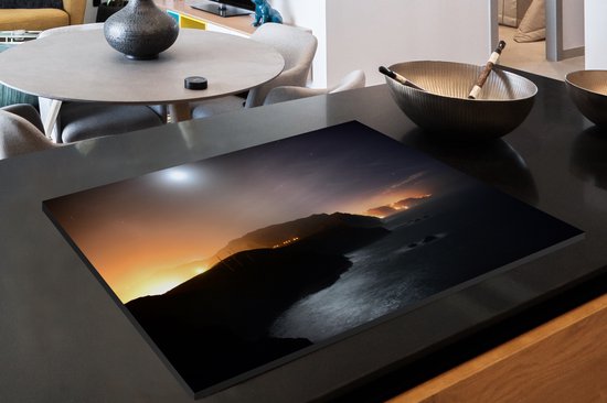 KitchenYeah® Inductie beschermer 78x52 cm - Stadslichten schijnen in de nacht van Madeira langs het zeewater - Kookplaataccessoires - Afdekplaat voor kookplaat - Inductiebeschermer - Inductiemat - Inductieplaat mat
